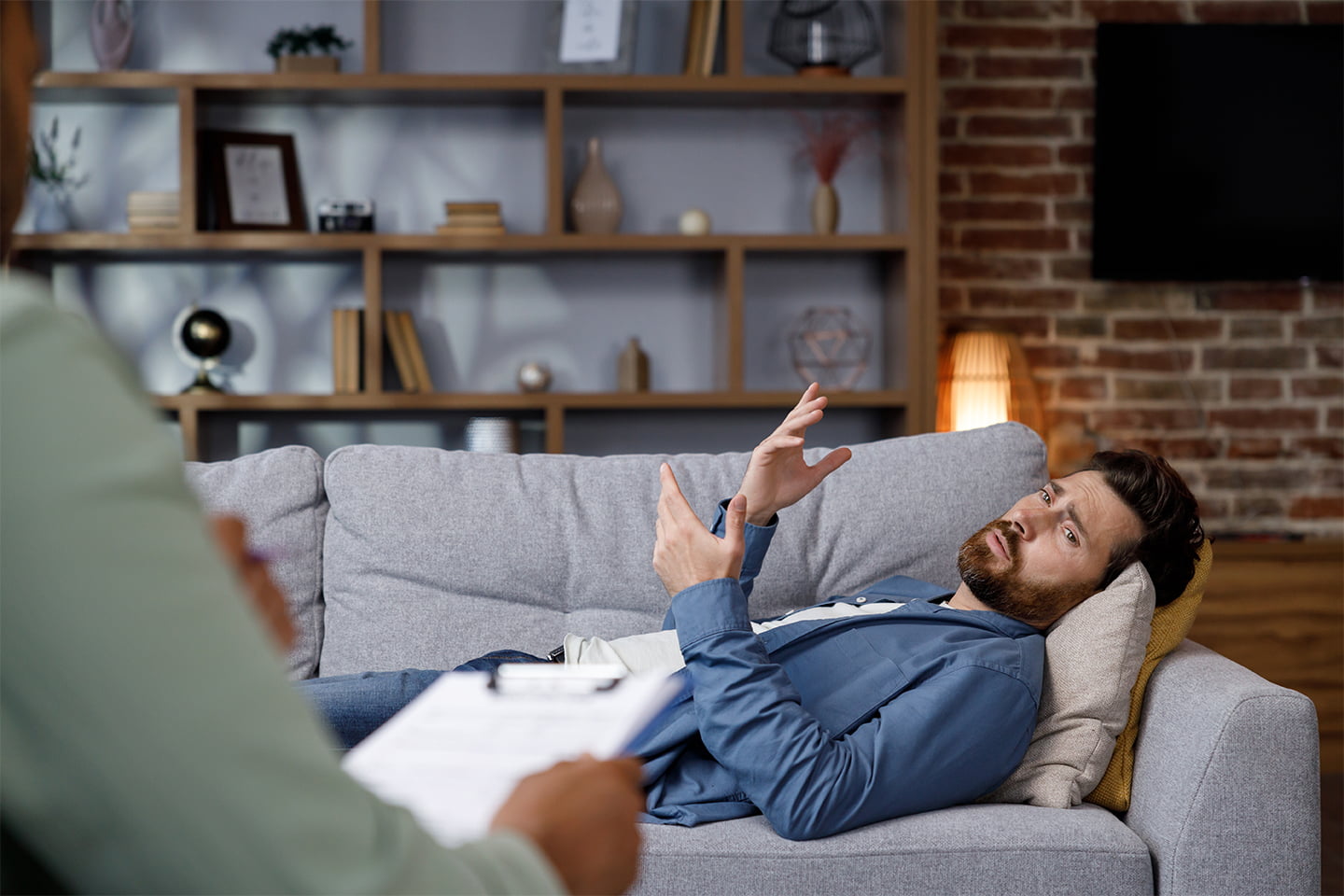 Man laying on couch talking to therapist